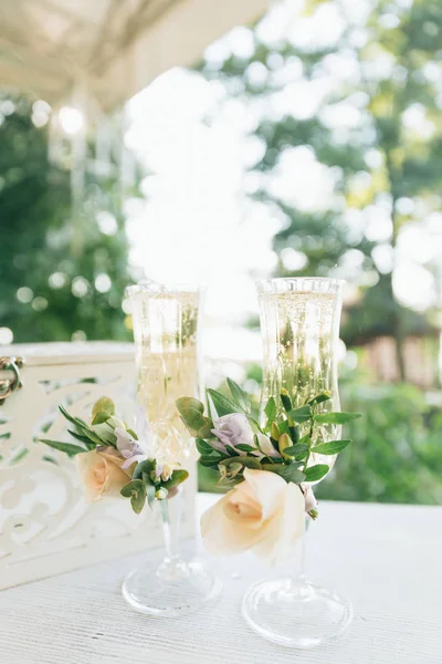 Due bicchieri con champagne per gli sposi. Decorazione nuziale da fiori freschi . — Foto Stock
