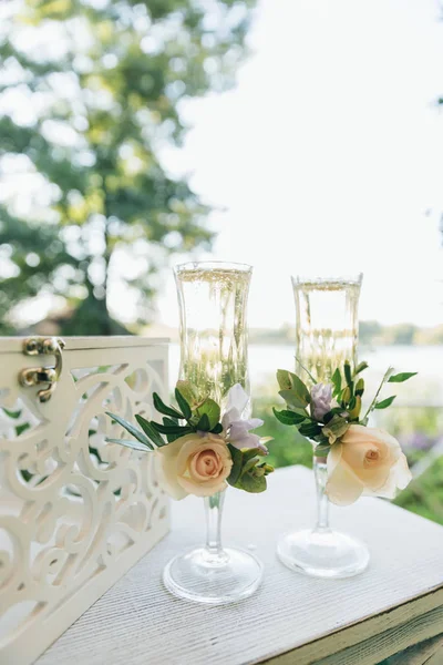 Due bicchieri con champagne per gli sposi. Decorazione nuziale da fiori freschi . — Foto Stock