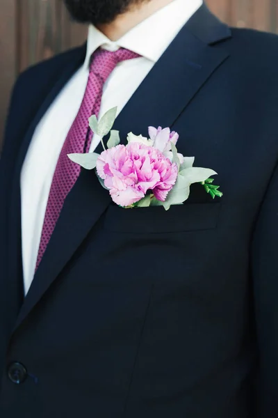 Man in a suit and bow-tie close up. On the jacket - buttonhole, boutonniere. suit of the groom in a blue suit close-up.