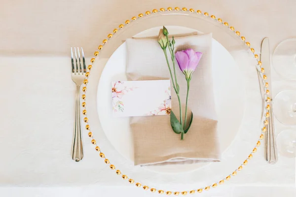 Apparecchiare la tavola nuziale. Piatto trasparente con fiori freschi . — Foto Stock