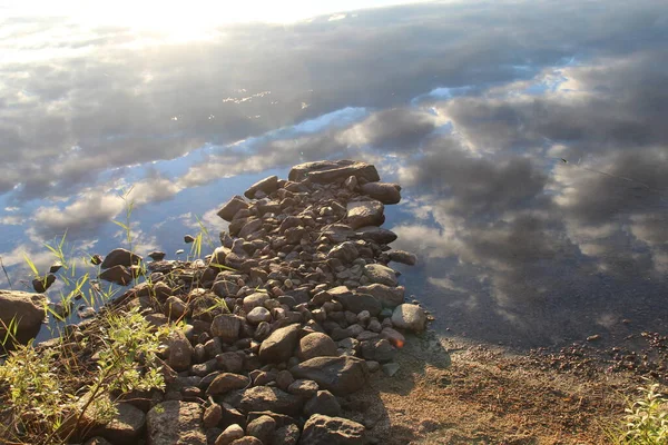 Reflection of the sky in a lake with a rocky path