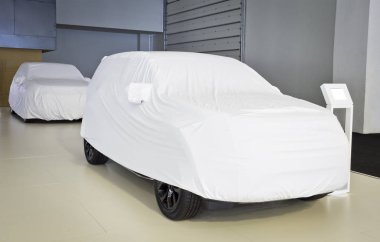 İki araba beyaz örtüyle kaplı