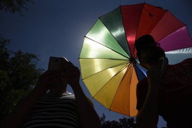 Belgrade, Sırbistan - Haziran 24,2017 - siluetleri iki adam, bir cep telefonu ve diğer ile eşcinsel gurur geçit töreninde Belgrad, Sırbistan üzerinde 24 Haziran 201