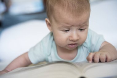 Yalan ve büyük bir kitap okumaya çalışan şirin bebek kız portresi 