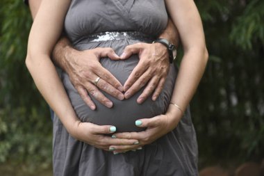 Mutlu güzel bekliyordum genç çift, koca kucaklama hamile eşi