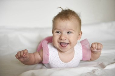 Bebek kız başını tutarak mide üzerinde yalan