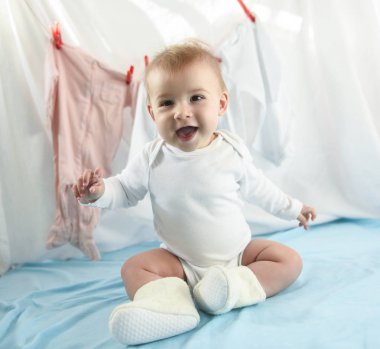 Adorable baby girl with laundry hanging