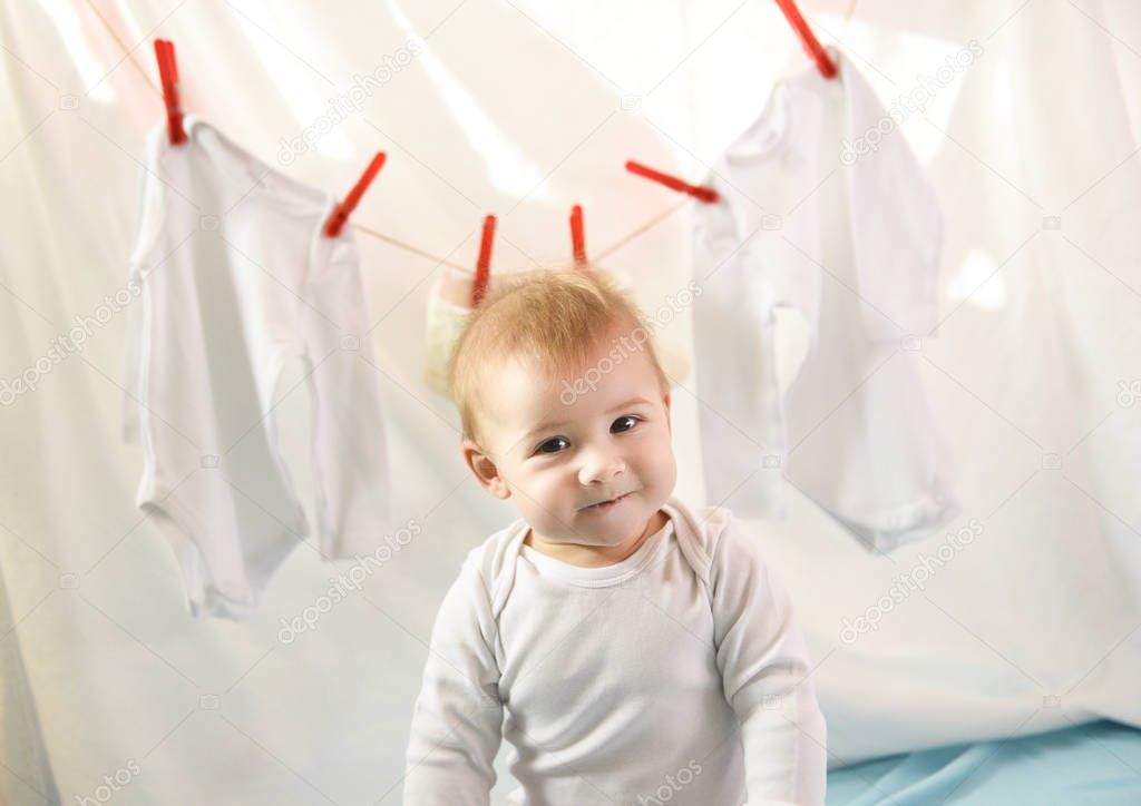 Adorable baby girl with laundry hanging