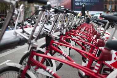 Barselona, İspanya - 4 Eylül 2014: Barcelona kiralık kırmızı şehir bisiklet. Modern çevre dostu ulaşım. Bir sıra park edilmiş bisiklet. Seçici odaklama.