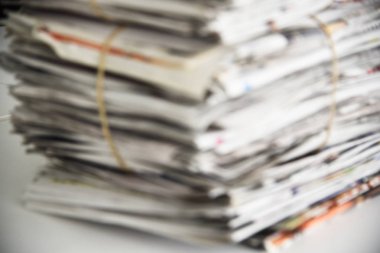 Bir yığın gazeteyi, arka plan dokusunu bulanıklaştırmış. Manşetleri, makaleleri ve fotoğrafları olan bir sürü eski dergi.