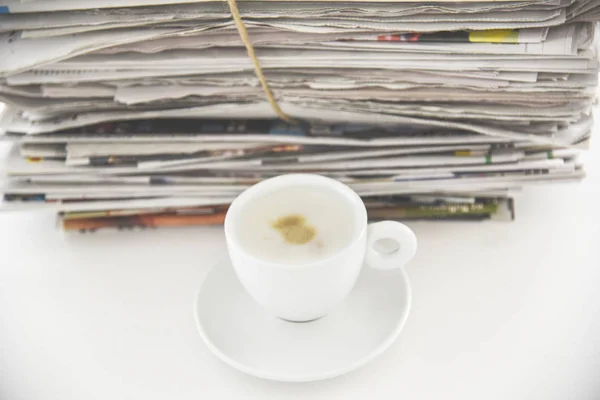 Take a break concept picture, pile of newspapers and cup of coffee on the table