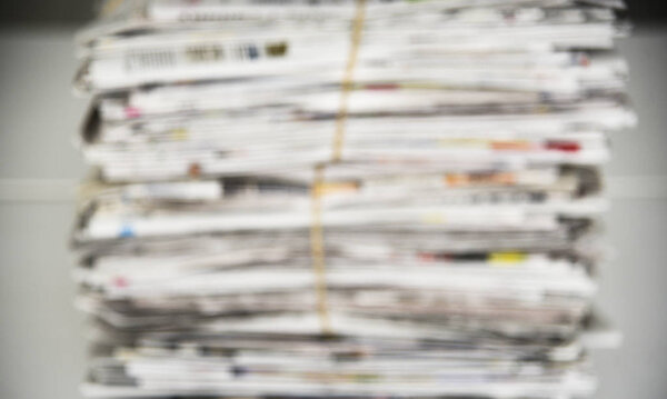Blurred a pile of newspaper, background texture. Lots of retro journals with headlines, articles and photos