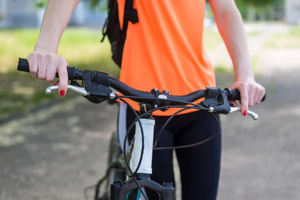 Woman hands on a bicycle handlebar close-up. Active lifestyle.