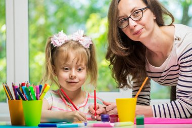 Mutlu bir aile. Anne ve kızı birlikte boya. Kadın kız çocuk yardımcı olur..