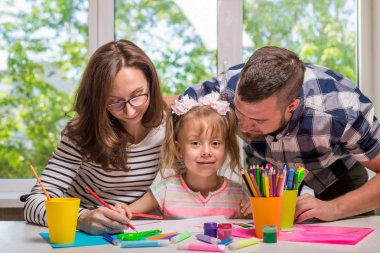 Annem ve babam okul için ev ödevi yapmak onların küçük kız yardım. Mutlu bir aile.