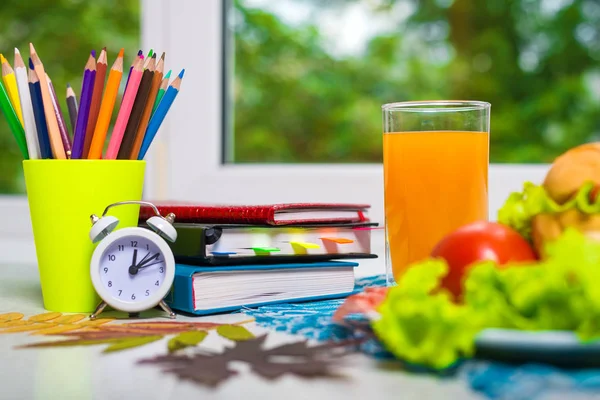 ?oncept of school lunch. School accessories and an appetizing lunch on the table, free space.