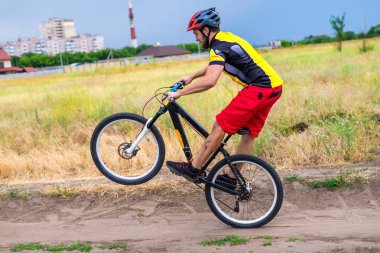 Bisikletçi bisiklet, aktif yaşam tarzı arka tekerlek üzerinde sürme. Şehir dışında yaz Bisiklet turu.