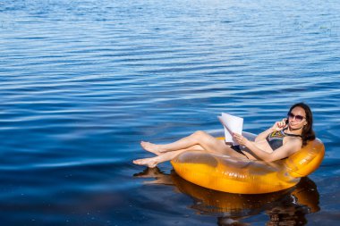 Tatile, uzak iş kavramı çalışan işkolik kadın. İş kadını deniz ve Evet, şişme bir yüzüğe oturan boş alan.
