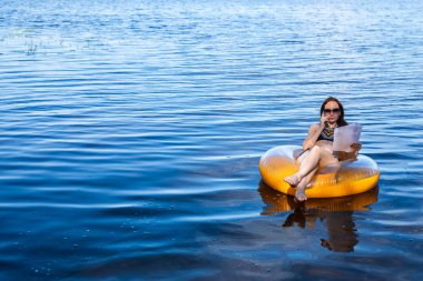 Uzak iş kavramı. Tatil sırasında boş alan deniz şişme bir halkada oturan çalışma iş kadın işkolik.