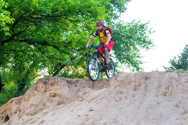 Professional enduro cyclist rides a mountain bike, free space. Extreme cycling, mtb. Sport and Enduro Biking Concept.