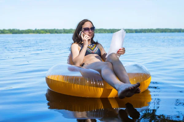 Kadın Yöneticisi zaman kapalı özgür yer üstünde çalışıyor. İş kadın Nehri üzerinde bir şişme ringde otururken söz.