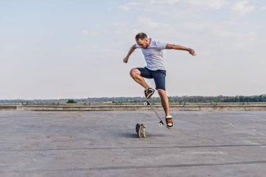 Mavi gökyüzü arka plan üzerinde bir ollie hile yaparak kaykaycı. Aktif yaşam tarzı.