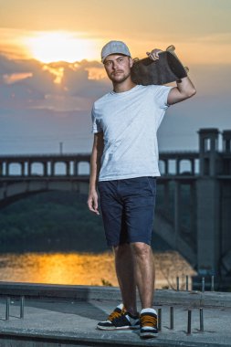 Genç erkek kaykaycı renkli günbatımı bir arka plan üzerinde boş alan. Aktif yaşam tarzı.