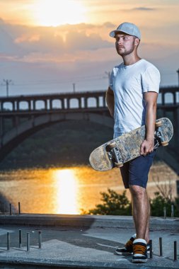 Genç erkek kaykaycı renkli günbatımı bir arka plan üzerinde boş alan. Aktif yaşam tarzı.