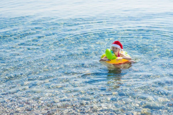 Kislány Úszik Tenger Egy Felfújható Gyűrű Egy Santa Kalap Szabad — Stock Fotó