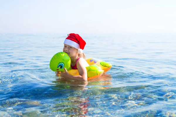 Kleines Mädchen Schwimmt Meer Einem Aufblasbaren Ring Mit Weihnachtsmütze Freier — Stockfoto