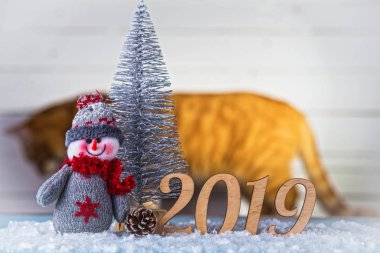 Yeni yıl kompozisyon: kardan adam, yazıt 2019 ve Noel ağacı ahşap arka plan üzerinde. Noel arka plan kopya alanı ile.