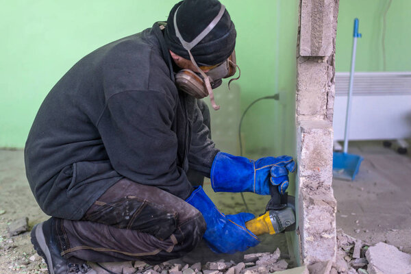 Construction worker cutting concrete wall by using electric cutter. Dangerous work. Construction works