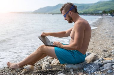 Uzak iş kavramı: Real iken bir dizüstü bilgisayar üzerinde çalışan iş adamı