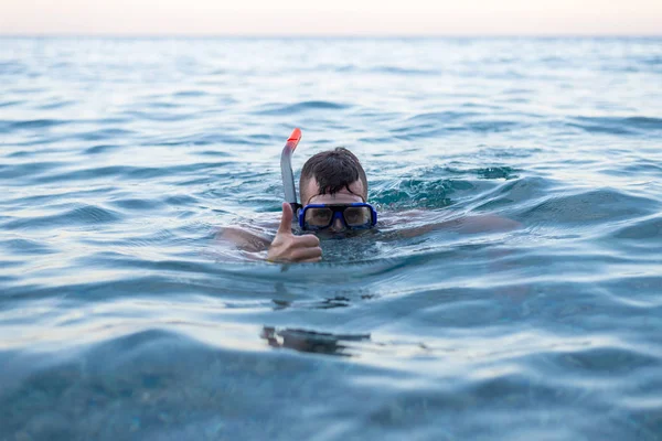 Homem nadando em uma máscara para mergulho e mostrando um sinal de aprox. . — Fotografia de Stock