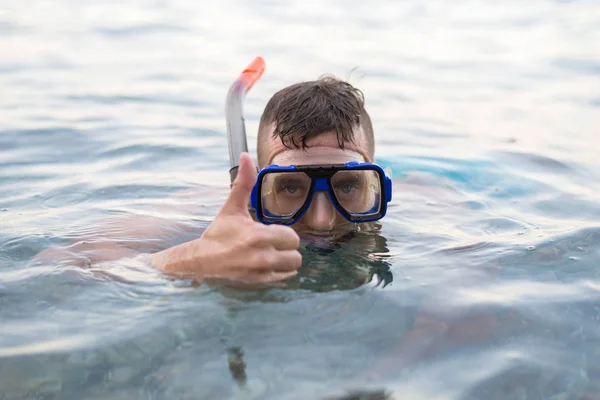 Homem nadando em uma máscara para mergulho e mostrando um sinal de aprox. . — Fotografia de Stock