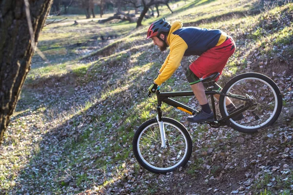 Professionell cyklist i en gul tröja och röda shorts som kör nedför en kulle, ledigt utrymme. Aktiv livsstil. — Stockfoto