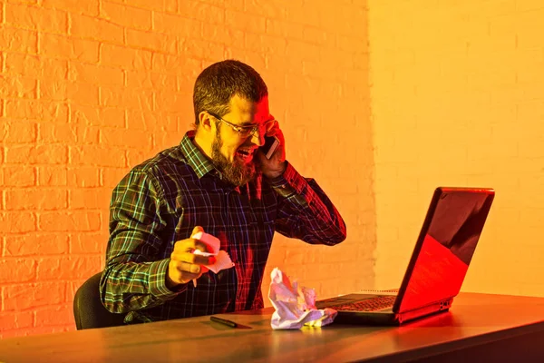 Angry cheerless man expressing his emotions while tearing down a sheet of paper.