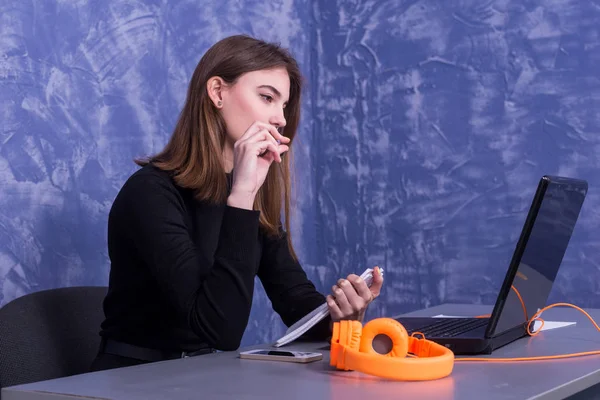 Mujer de negocios trabajando en un ordenador portátil y escribiendo en un cuaderno, trabajo distante . — Foto de Stock