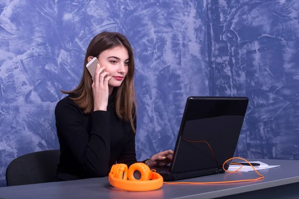 Mujer de negocios trabajando en un ordenador portátil y hablando por teléfono, trabajo distante . — Foto de Stock