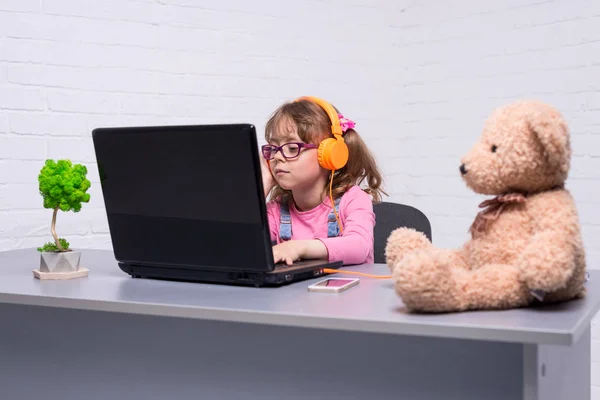 Niña en gafas con un portátil — Foto de Stock