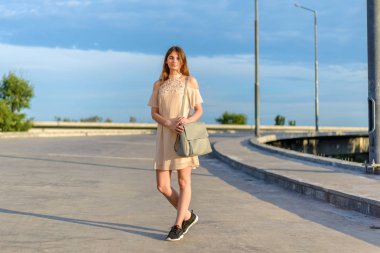 Genç bir kız yol boyunca yürüyor, bir yolculuk.