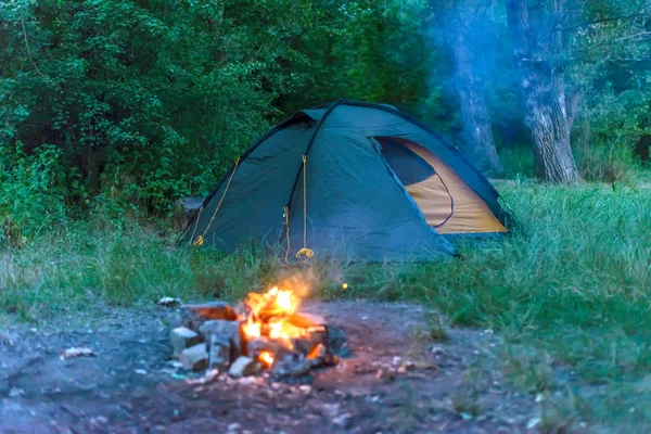 Tente touristique et feu dans la forêt, espace libre — Photo