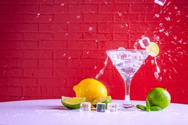 Bir martini cam vermut ve kırmızı bir arka plan üzerinde kireç bir dilim, kopya alanı.