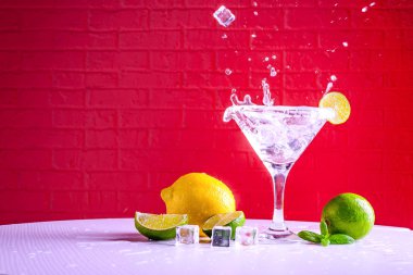Bir martini cam vermut ve kırmızı bir arka plan üzerinde kireç bir dilim, kopya alanı.