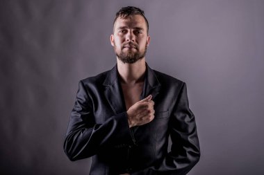 Ceketli sakallı adam yakın çekimde.