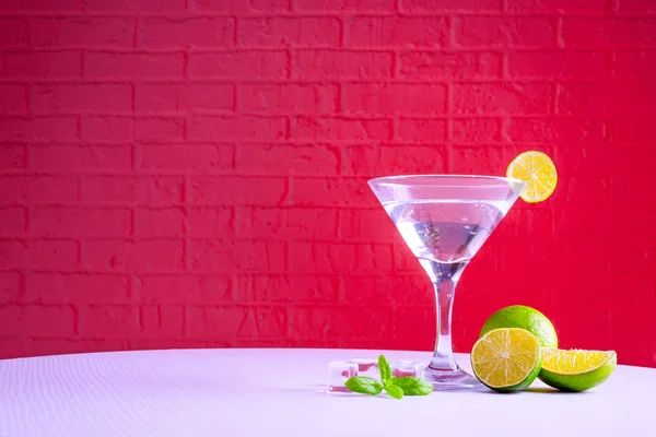 Bir martini cam vermut ve kırmızı bir arka plan üzerinde kireç bir dilim, kopya alanı. — Stok fotoğraf