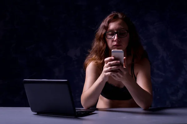 Woman freelancer uses a laptop at night, a workaholic.