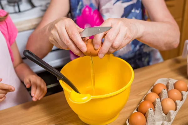 Grandmother and little granddaughter prepare the dough for the cake. — Stock Photo, Image