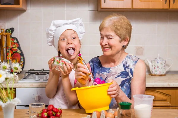 Grandmother and little granddaughter prepare the dough for the cake. — Stock Photo, Image