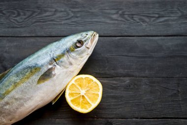 Ahşap siyah arka plan üzerinde taze ton balığı ve limon, kopya alanı ile üst görünümü.